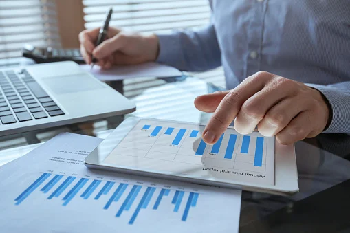 Consultant reviewing printed operational reports and charts at a desk